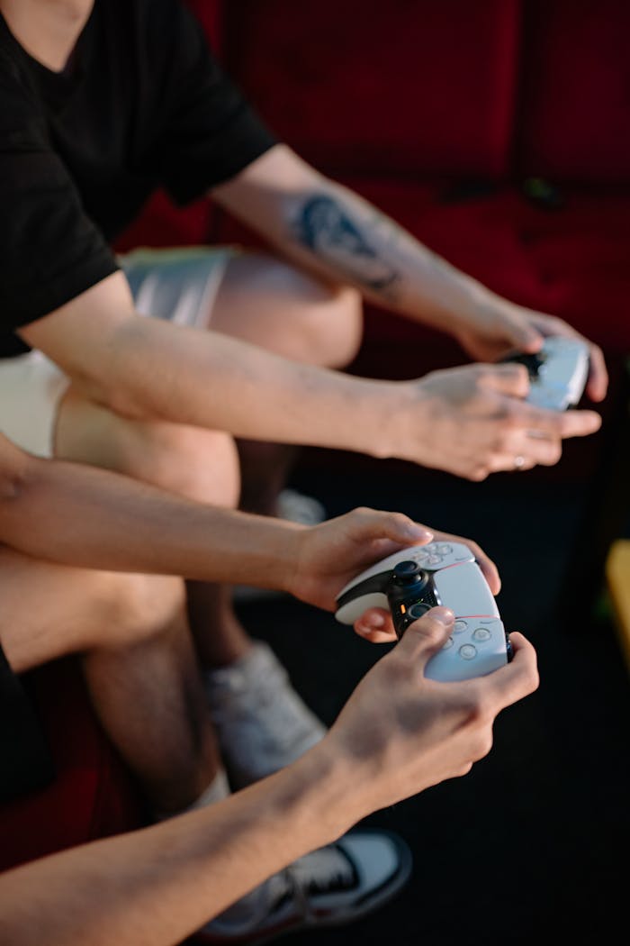 hero-img-02 Close-up of friends playing video games indoors with wireless controllers.